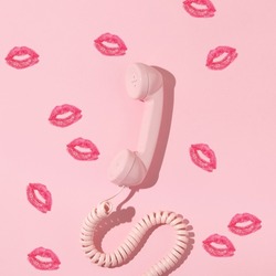 Valentines Day Creative Layout With Pink Retro Phone Handset And Kiss Prints On Pastel Pink Background. 80s, 90s Retro Fashion Aesthetic Telephone And Kiss Concept. Minimal Romantic Communication Idea
