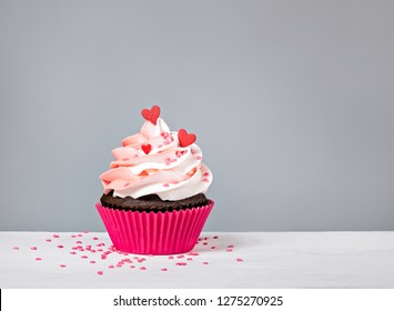 Valentines Day Cupcake Treat With Buttercream Icing And Heart Sprinkles On A Grey Background