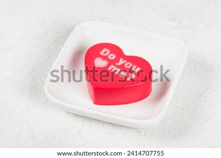 Valentine's Day dessert. Strawberry chocolate cream mousse cake in the shape of a heart with thematic inscriptions on top 
