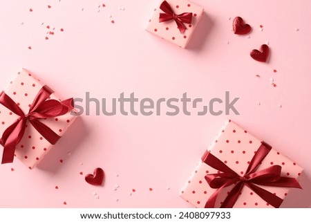 Valentine's Day flat lay composition with gift boxes and hearts on pastel pink background. Flat lay, top view, copy space.