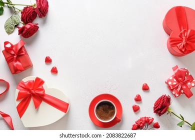 Valentine's day frame with love gifts, coffee, bouquet of red roses on white background. Romantic greeting card for dating. View from above. Copy space.