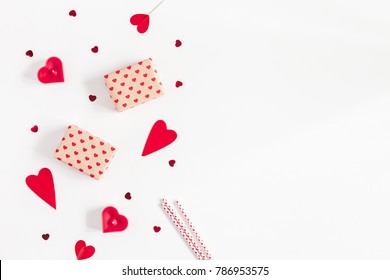 Valentine's Day. Frame made of gifts, candles, confetti on white background. Valentines day background. Flat lay, top view, copy space.