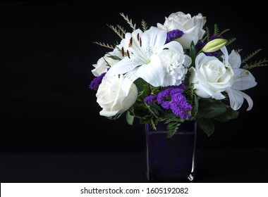 Valentines Day Funeral Bouquet Purple White Flowers, Sympathy And Condolence Concept On Black Background With Copy Space.