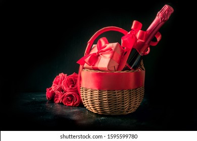 Valentines Day Gift Hamper, Bouquet Of Red Roses, Bottle Of Sparkling Wine On Black Table. Close Up. Horizontal Format. Space For Wishes.