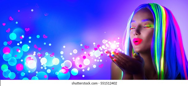 Valentine's Day Girl On Disco Party. Fashion Model Woman In Neon Light, Blowing Valentine Neon Hearts. Beautiful Model Girl, Painted Fluorescent Make-up, Body Art Design Of Female In UV. Night Club