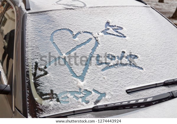 valentines day\
graffiti in snow on windscreen of\
car