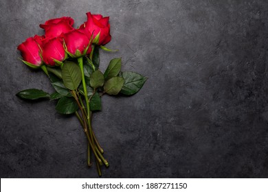 Valentinstag Grußkarte mit roten Rosenblumen, Bouquet auf dunklem Hintergrund. Top-View-Wohnung mit Platz für Ihre Grüße