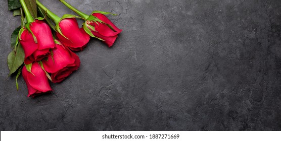 Valentines day greeting card with red rose flowers bouquet over dark stone background. Top view flat lay with space for your greetings - Powered by Shutterstock