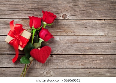 Valentines Day Greeting Card. Red Rose Flowers And Gift Box On Wooden Table. Top View With Space For Your Greetings 