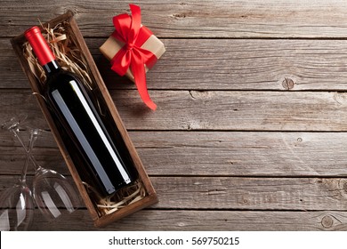 Valentines Day Greeting Card. Red Wine, Gift Box And Glasses On Wooden Table. Top View With Space For Your Greetings