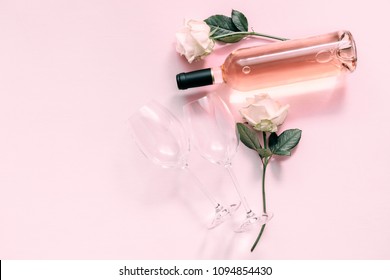 Valentines Day Greeting Card.  White Roses, Wine And Glasses For Wine On A Soft Light Pink On Wood Table. Flat Lay, Top View, Copy Space