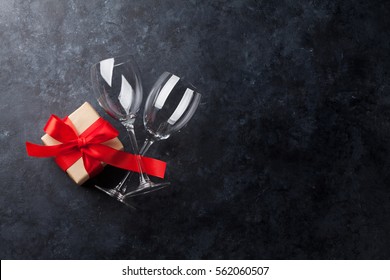 Valentines Day Greeting Card. Wine Glasses And Gift Box On Stone Table. Top View With Copy Space 