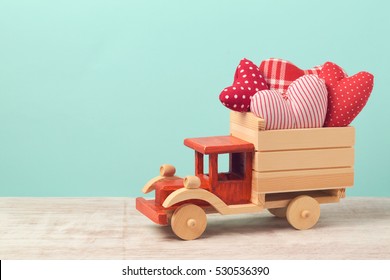 Valentine's day holiday concept with toy truck and heart shapes over mint background - Powered by Shutterstock