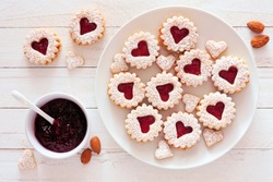 Valentines Day Jam Filled Cookies With Heart Shapes. Top View Table Scene Against A White Wood Background.