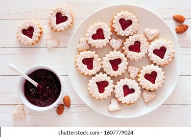 Valentines Day jam filled cookies with heart shapes. Top view table scene against a white wood background.