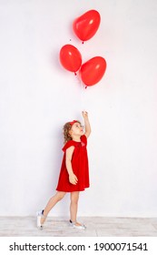 Valentine's Day Kids. Little Girl In Red Dress Holding Heart Shaped Balloons