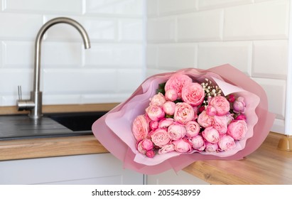 Valentine's Day and kitchen interior. For my Valentine. Close-up photo of a bouquet of  pink roses which lie on a kitchen table.