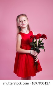 Valentines Day. Little Cute Girl In Red Dress Holding Red Roses On Pink Studio Background