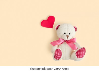 Valentine's Day. Love heart. Teddy Bear and Red Heart on Neutral Beige Color Pastel Background. Vintage Retro Romantic Style. Unusual Creative Greeting Card. Family, Wedding and Friendship. Top View
