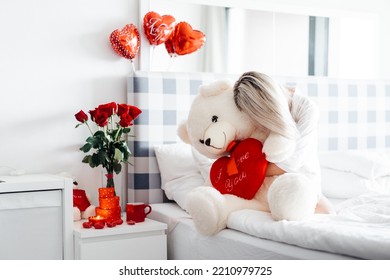 Valentine's day, lovers' day with red flowers, a white teddy bear holding a big red heart