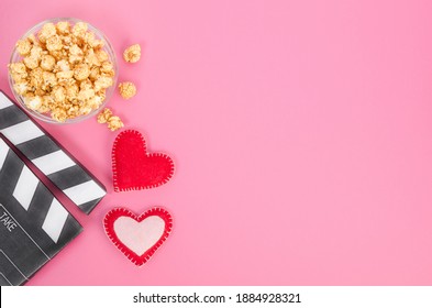 Valentine's Day movie concept. Movie clapperboard with hearts and caramel popcorn with copy space
