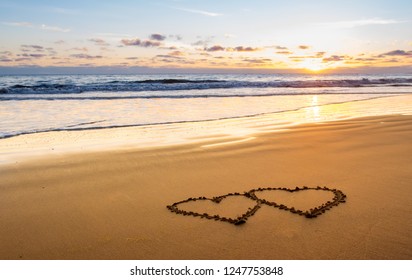 Valentines day on sunny beach. Two hearts drawn in sand, love concept
