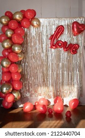 Valentine's Day Photo Zone With Tear Drop Curtain And Balloons. Red Hearts And The Word Love On A Golden Background.