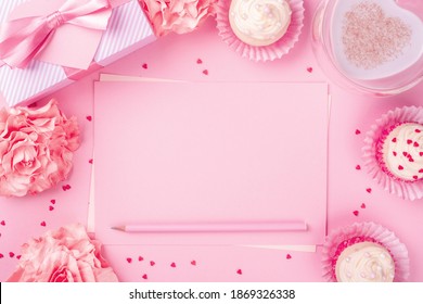 Valentines day pink background with blank love letter with copy space gift box rose flowers cupcakes pencil and drink - Powered by Shutterstock