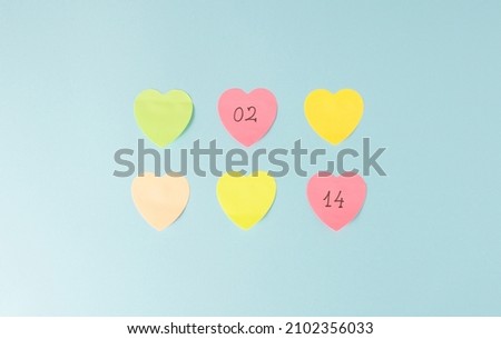 Valentine's Day post it notes reminder on a pale blue background. Minimal concept.