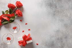 Valentine's Day Romantic Concept With Sparkling Wine, Gift , Hearts And Red Roses On Gray Background. View From Above. Copy Space.