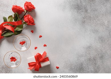 Valentine's day romantic concept with sparkling wine, gift , hearts and red roses on gray background. View from above. Copy space. - Powered by Shutterstock