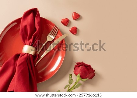 Valentine's day romantic table setting with red plate and red roses on beige background. View from above. Copy space. Festive dinner.