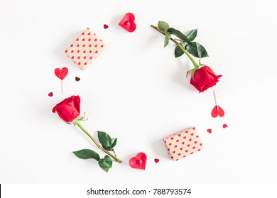 Valentine's Day. Round frame made of rose flowers, gifts, candles, confetti on white background. Valentines day background. Flat lay, top view, copy space.
