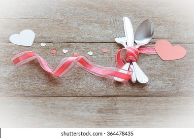 Valentines day set with silverware and heart on wooden table background