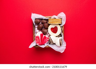 Valentines Day sweets and cookies in wooden box on red background. Chocolate, meringue, marshmallow, linzer cookies, gingerbread. Mother's day, Women's day. Homemade present. Copy space, top view. - Powered by Shutterstock