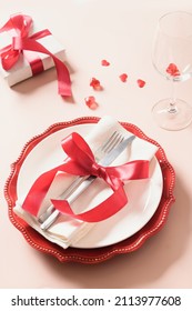 Valentines Day Table Setting With Gift, Red Roses, Hearts On Pink Background. Valentine's Invitation To Dinner. Vertical Format.