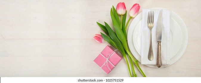 Valentines Day Table Setting With Pink Tulips And A Gift Box On White Wooden Background. Top View, Banner, Space For Text