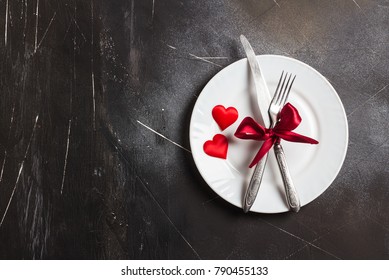 Valentines day table setting romantic dinner marry me wedding with plate fork knife on dark background with copyspace. Love gift woman making proposal romantic holiday wedding