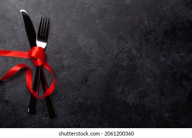 Valentines day table template background with silverware and red ribbon. Top view flat lay with copy space