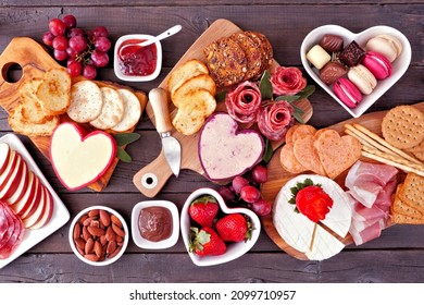 Valentine's Day Theme Charcuterie Table Scene Against A Dark Wood Background. Assorted Cheese, Meat, Fruit And Sweet Appetizers. Top Down View.