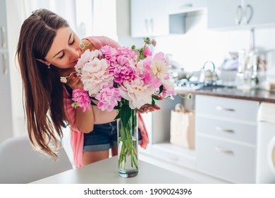 Valentine's day. Woman smelling bouquet of peonies at home. Housewife received present for holiday. Allergy free - Powered by Shutterstock