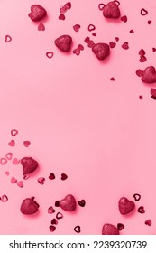 San Valentín, amor e ideas de bodas. Enmarcar corazones rojos con fondo rosado. Piso plano, vista superior. Color de moda del año 2023 - Viva Magenta. Foto de stock