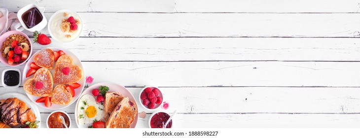 Valentines Or Mothers Day Brunch Corner Border. Top Down View On A White Wood Banner Background. Heart Shaped Pancakes, Eggs And A Variety Of Love Themed Food.