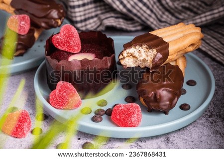 Valentinesday cupcake. Dark chocolate coated digestive biscuit . Sweet delicious dessert truffle and heart shaped candy on a plate. Dark Background with Copy space.
