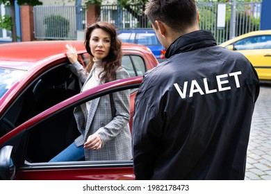 Valet Opening Private Car Door For Businesswoman