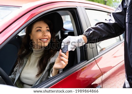 Valet Parking Giving Car Key To Young Woman