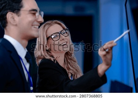 Validating the future AI. A specialist points out a crucial parameter in an AI model's code displayed on screen discussing its ethical implications with her colleague before deployment.