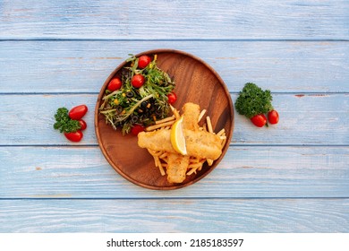 Valle Battered Cod Fish And Chips With Salad, Lime And Cherry Tomato Served In Dish Isolated On Wooden Table Top View Fastfood