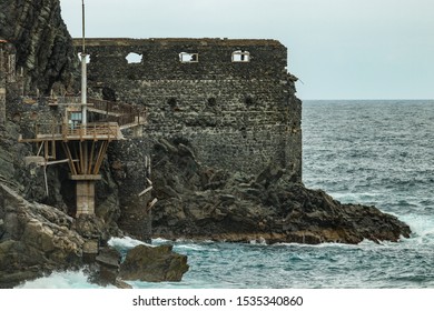 Vallehermoso Beach In La Gomera With Huge Waves Crashing On Basalt Rocks. Old Stone Building Named El Castillo Del Mar, An Old Banana Factory. Shot By Long Focus Lens. Canary Islands, Spain.