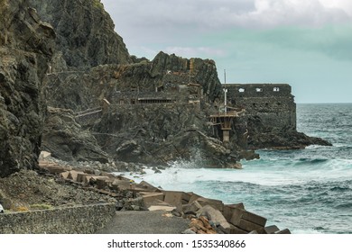 Vallehermoso Beach In La Gomera With Huge Waves Crashing On Basalt Rocks. Old Stone Building Named El Castillo Del Mar, An Old Banana Factory. Shot By Long Focus Lens. Canary Islands, Spain.